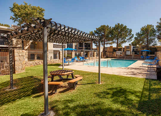 A backyard with a pool and a picnic table.