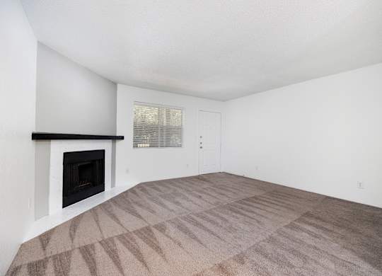 A room with a fireplace and carpeted floor.