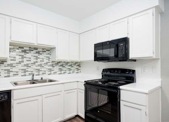 A black microwave oven is on top of a black stove.