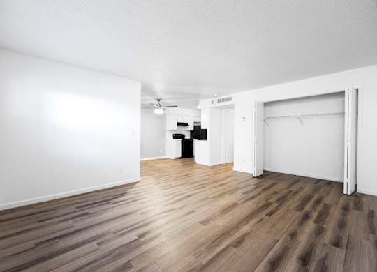 A room with wooden flooring and white walls.