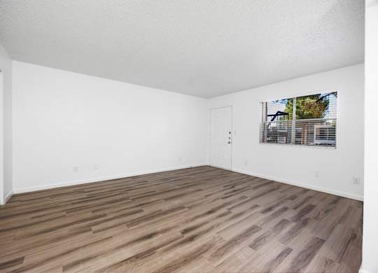 A room with wooden flooring and white walls.