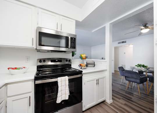 A kitchen with a stove, microwave, and oven.