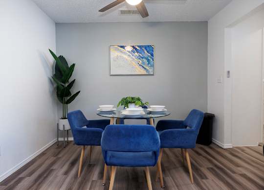 A dining room with a table and blue chairs.