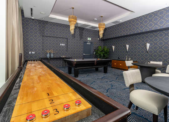 A shiny wooden table with numbered cups on it is in the middle of a room with a blue carpet.