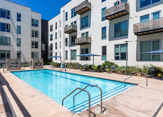 A swimming pool in front of apartment buildings.