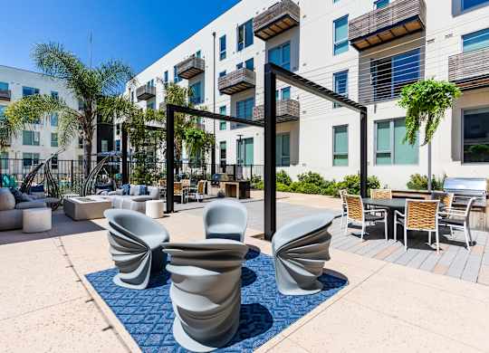 A modern outdoor seating area with blue and white chairs.