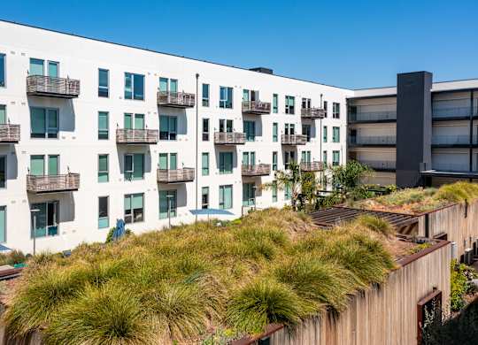 A modern building with a green roof and balconies.