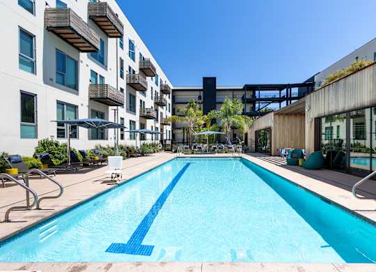 A large blue pool in the middle of a courtyard surrounded by buildings.
