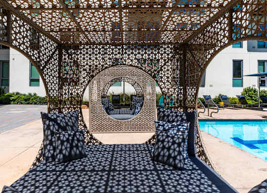 A large, intricate metal structure serves as a canopy over a black and white patterned couch.