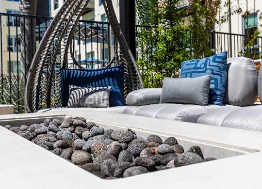 A modern outdoor seating area with a rock garden and a metal chair.