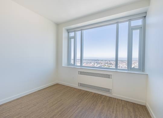 A room with a window overlooking a cityscape.