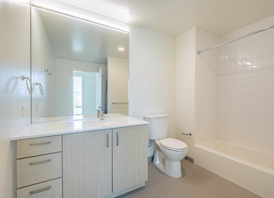 A white bathroom with a toilet, sink, and bathtub.