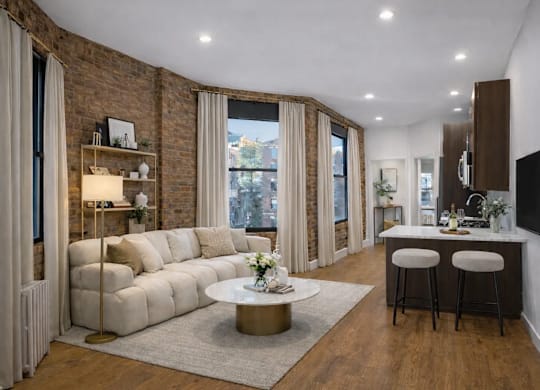 A modern living room with a white sofa, a coffee table, and a flat-screen TV mounted on the wall.