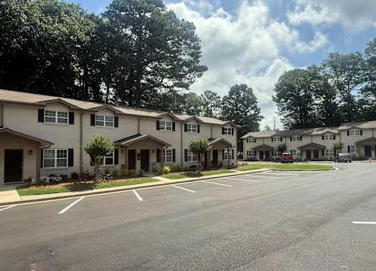 A row of houses with trees in the background at Waverly Manor Townhomes, Norcross, GA 30071