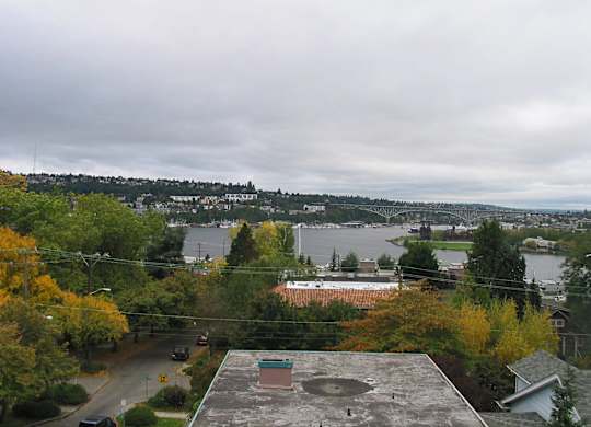 A view of a city from a high vantage point with a river in the foreground.