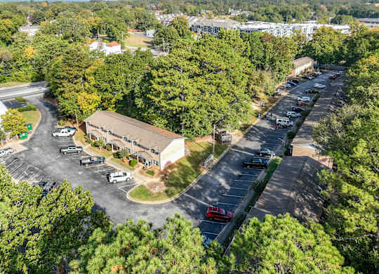 A parking lot with a building in the background and trees surrounding the area.at Waverly Manor Townhomes, Georgia  