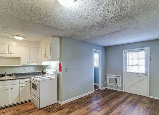 A kitchen with white cabinets and a wood floor.at Waverly Manor Townhomes, Norcross, GA 30071  