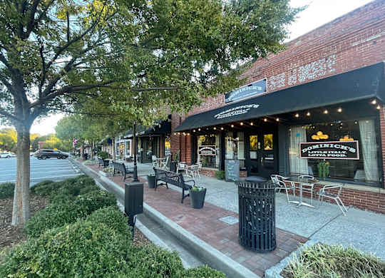 A street view of a city with a restaurant named Positano's.at Waverly Manor Townhomes, Norcross, 30071  