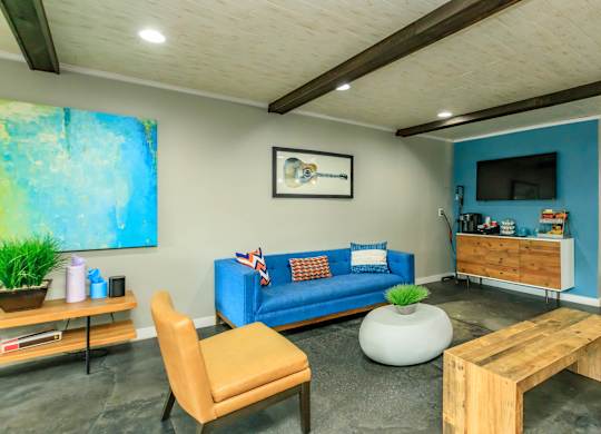 A living room with a blue couch and a wooden coffee table.