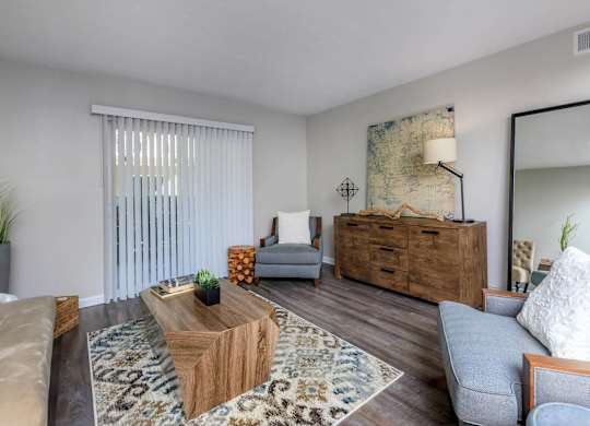 A living room with a wooden coffee table and a grey couch.