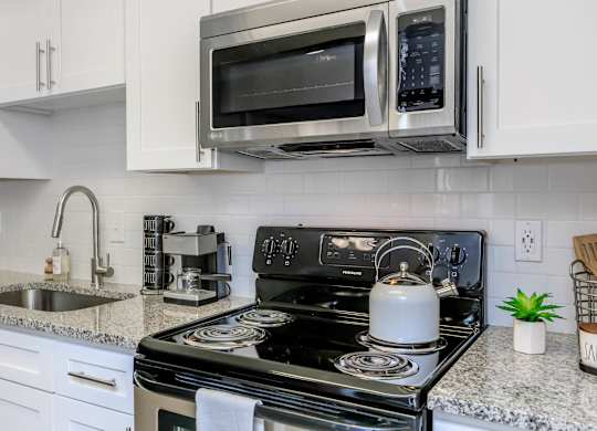 A black stove top oven with a kettle on it.