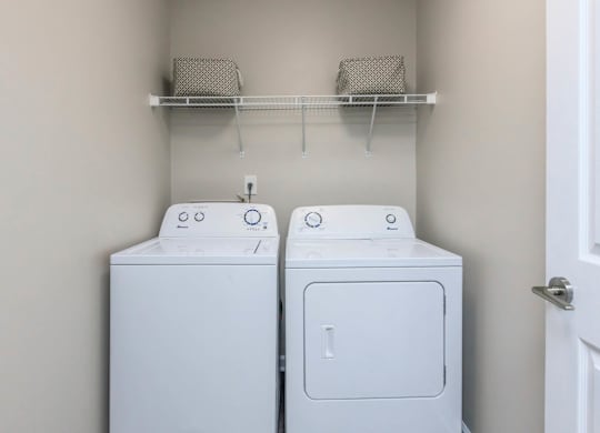 Two white washing machines in a laundry room.