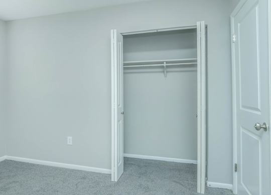 A white closet with a door open and a carpeted floor at Crest at East Cobb Apartments, Marietta, GA, 30062