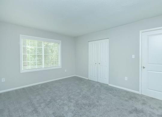 A room with a carpeted floor and two doors at Crest at East Cobb Apartments, Marietta