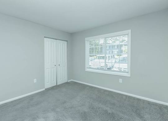 A room with a carpeted floor and a window with blinds at Crest at East Cobb Apartments, GA, 30062