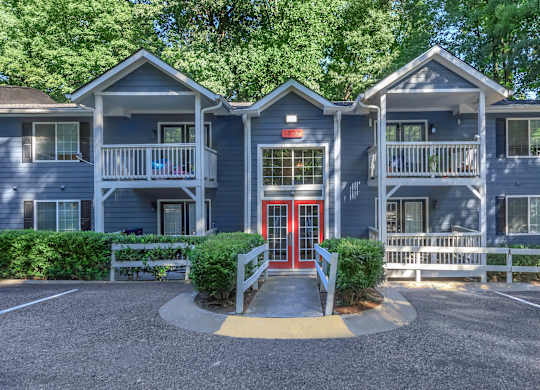 A building with a red door and a white fence in front at Crest at East Cobb Apartments, Marietta, GA