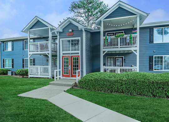 A blue building with a red door and a sign that says  at Crest at East Cobb Apartments, Georgia