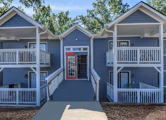 A small building with a red door and white railings at Crest at East Cobb Apartments, Marietta, GA