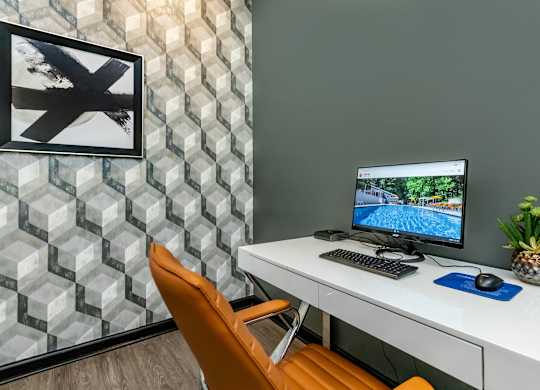 A white desk with a computer and a pineapple on it at Crest at East Cobb Apartments, Marietta, GA