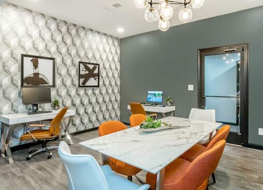 A conference room with a white table and orange chairs at Crest at East Cobb Apartments, GA, 30062