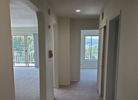 A long hallway with white walls and carpeting.