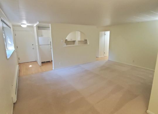 Empty room with white walls and carpeted floor.