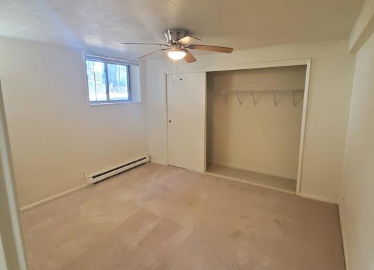 A room with a ceiling fan and a window.