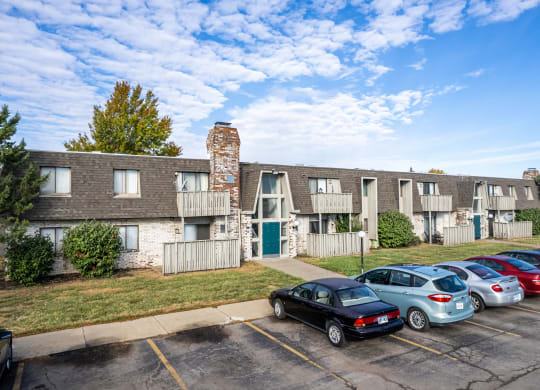 a parking lot with cars in front of an apartment building