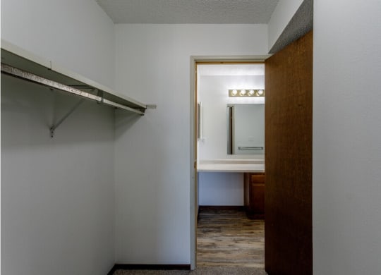 an empty room with a walk in closet and a mirror