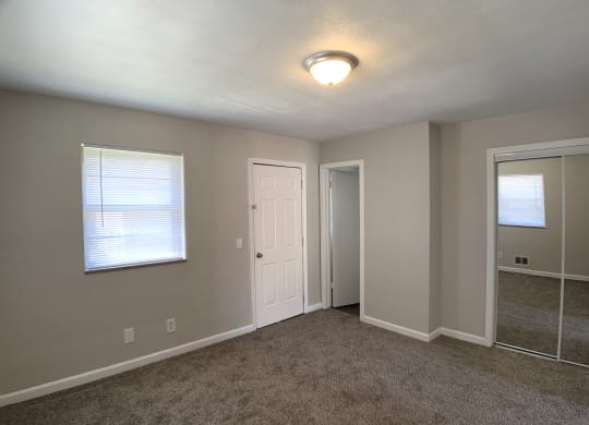 Room with mirrored closet and window