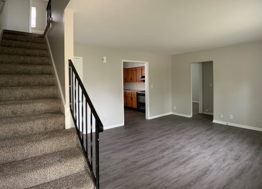 Spacious living room with open concept to kitchen and stairs