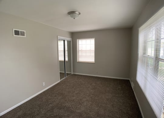 Spacious bed room with mirrored closets and 2 windows