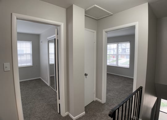 View of 2 bedrooms from top of stairs