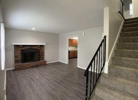 Living room area with fireplace and stairs at Roosevelt in Independence, MO