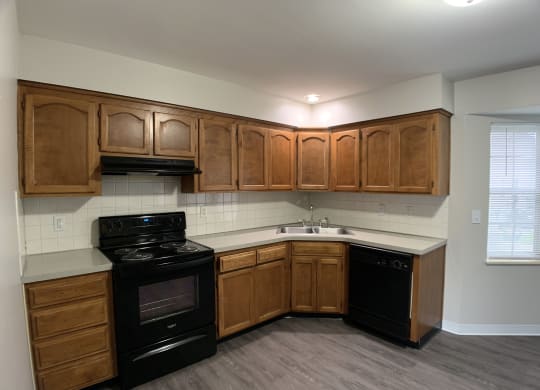 Kitchen with black stove and dishwasher at Roosevelt in Independence, MO