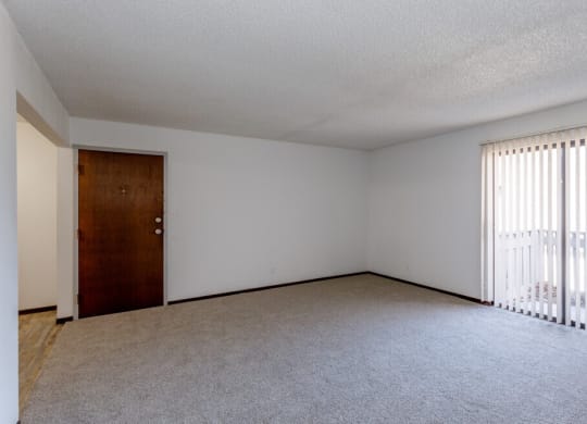 an empty bedroom with a door leading to a balcony
