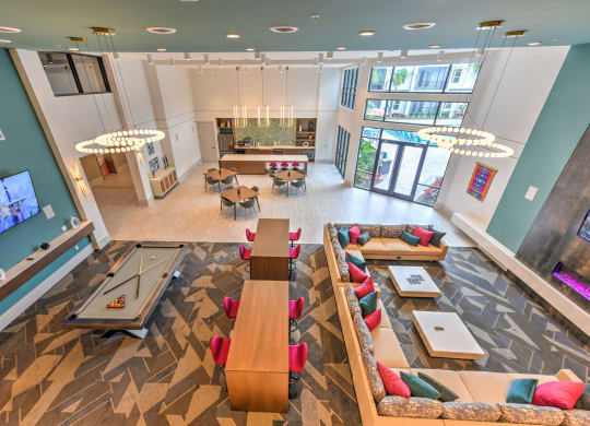 a communal area with couches and tables in a large room with a game room at Pinnacle Apartments, Jacksonville, 32256