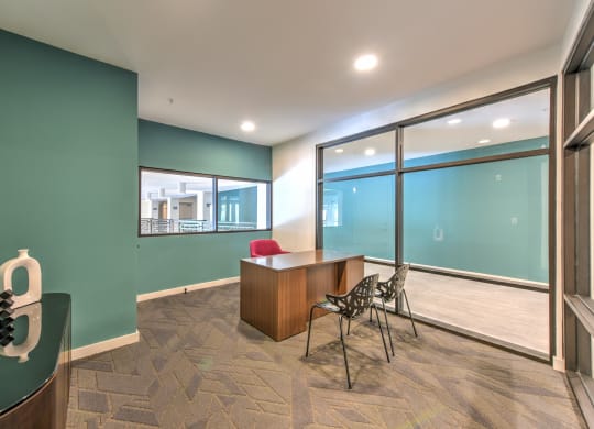 a conference room with large windows and a desk and chairs at Pinnacle Apartments, Jacksonville, 32256