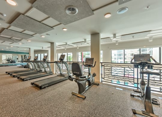 a gym with cardio equipment and windows at the heights at Pinnacle Apartments, Jacksonville, FL