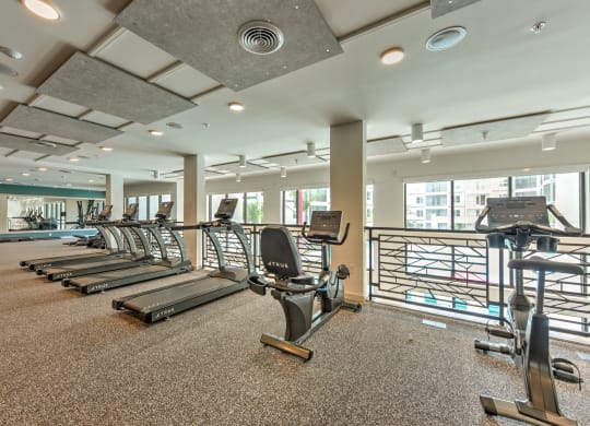 a gym with cardio equipment and windows at the heights at Pinnacle Apartments, Jacksonville, FL